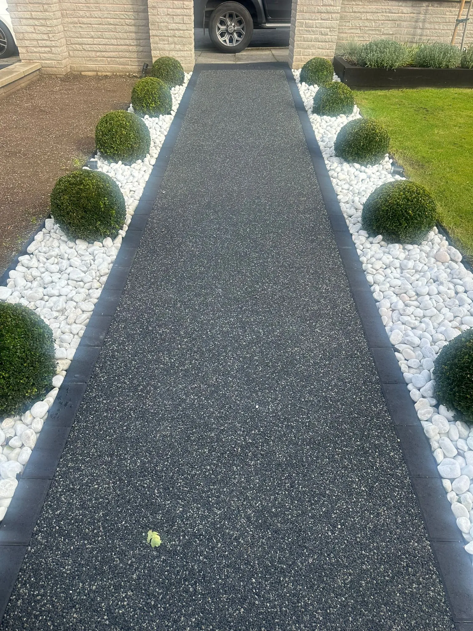 Black resin bound pathway through buxus garden