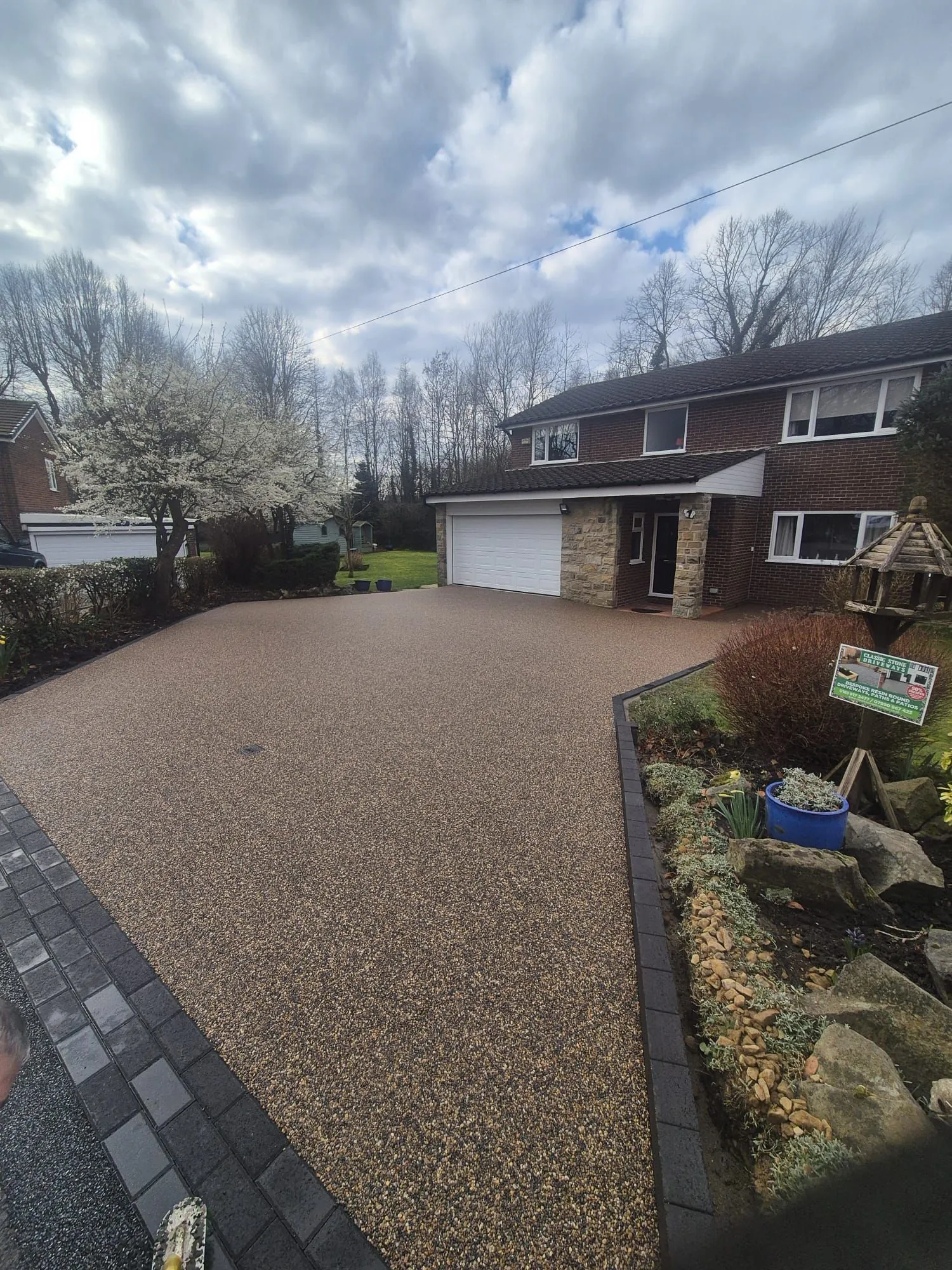 Bronze resin driveway at detached home in spring, Manchester
