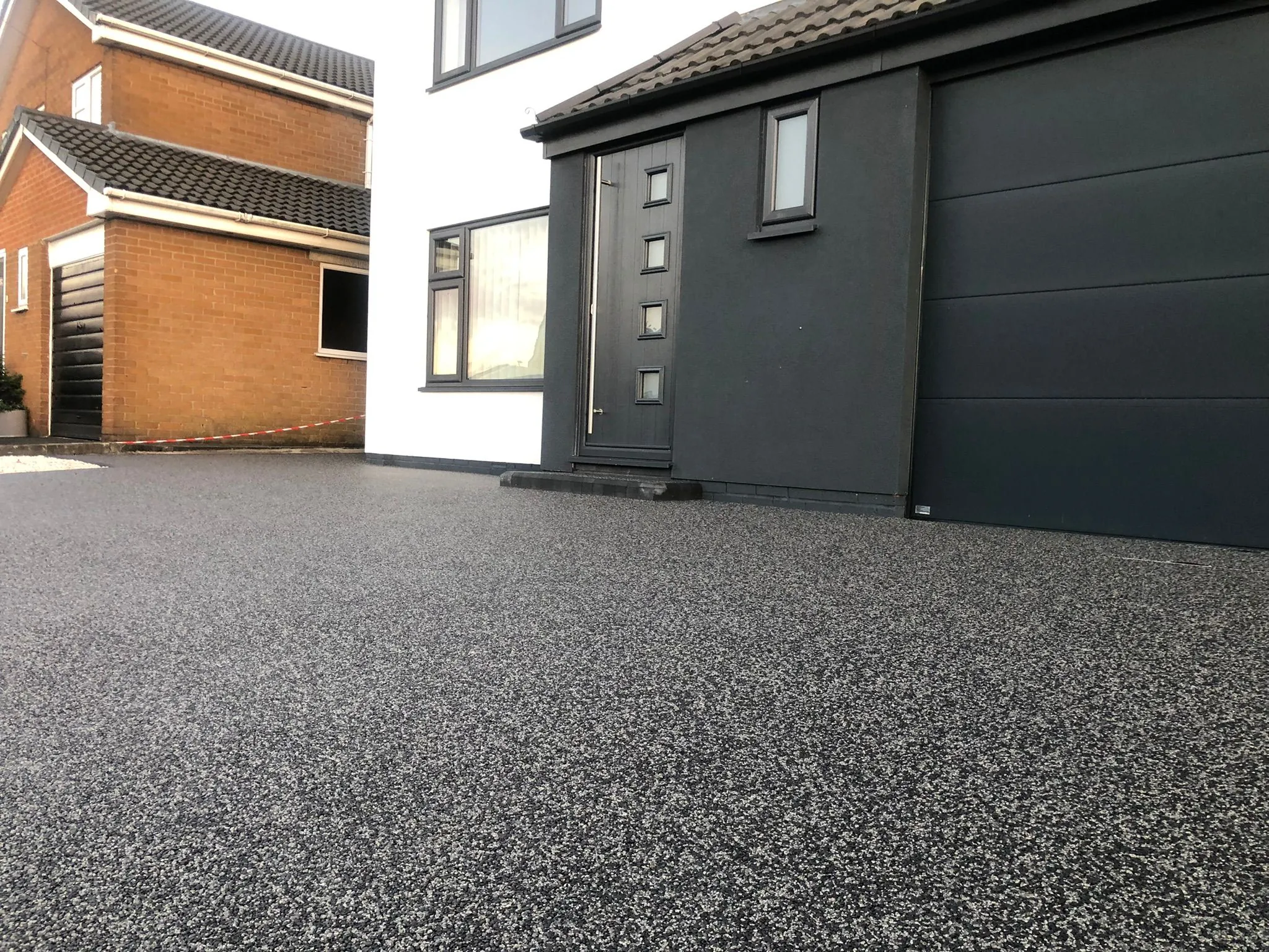 Charcoal resin drive with dark grey garage, Manchester