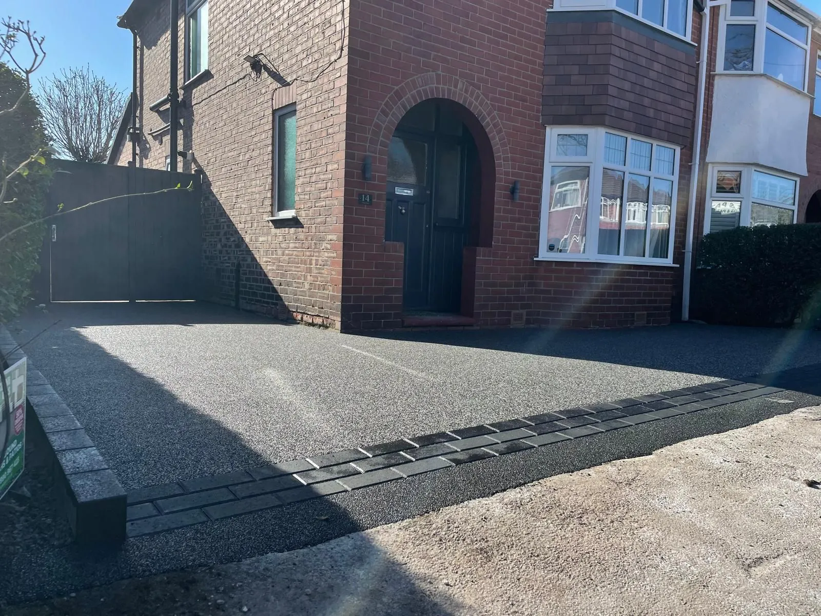 Charcoal resin driveway at arched red brick home, Manchester
