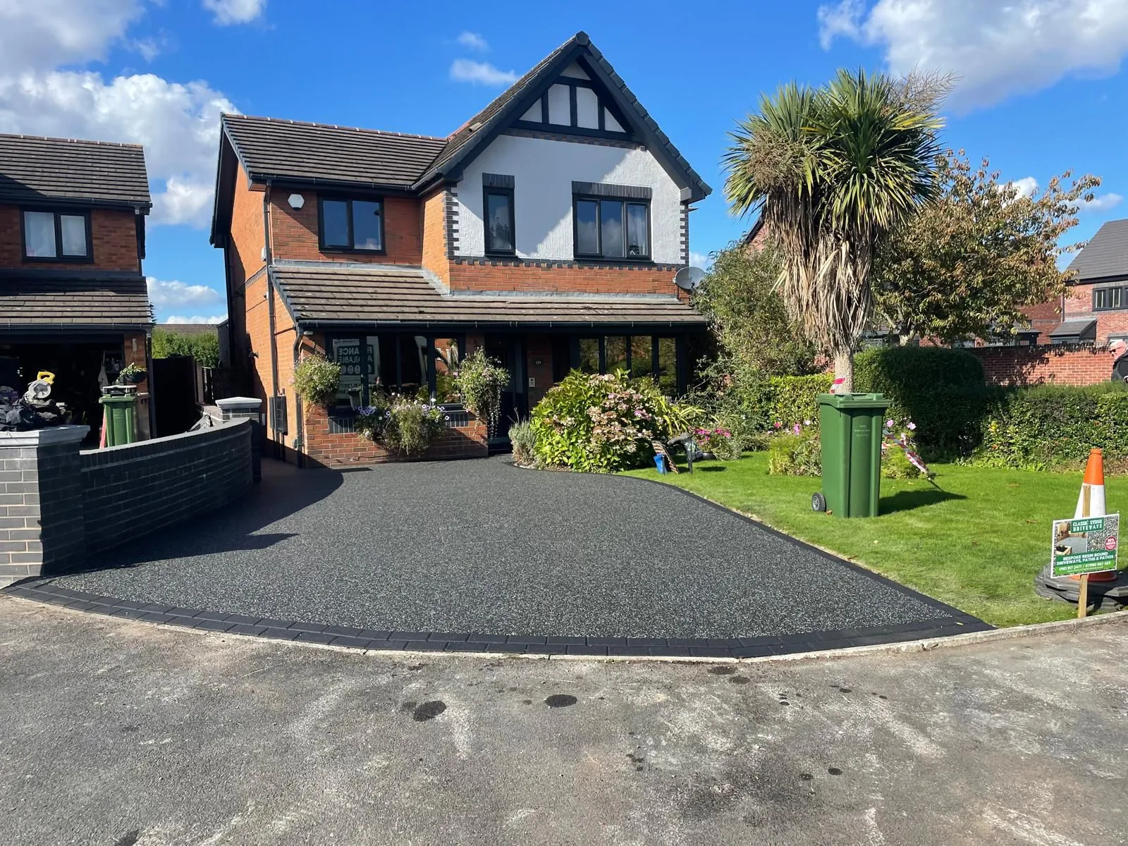Charcoal resin driveway at detached home on a sunny day