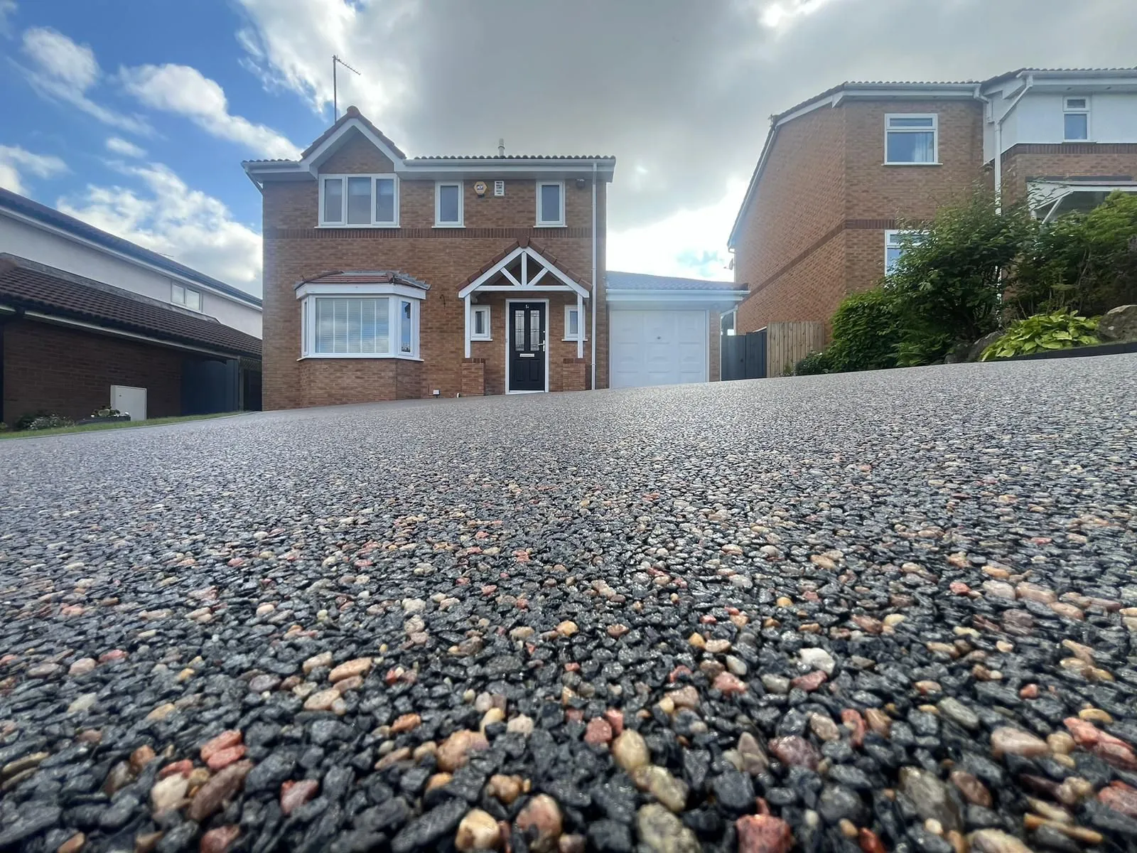 Charcoal resin driveway at detached home with white door
