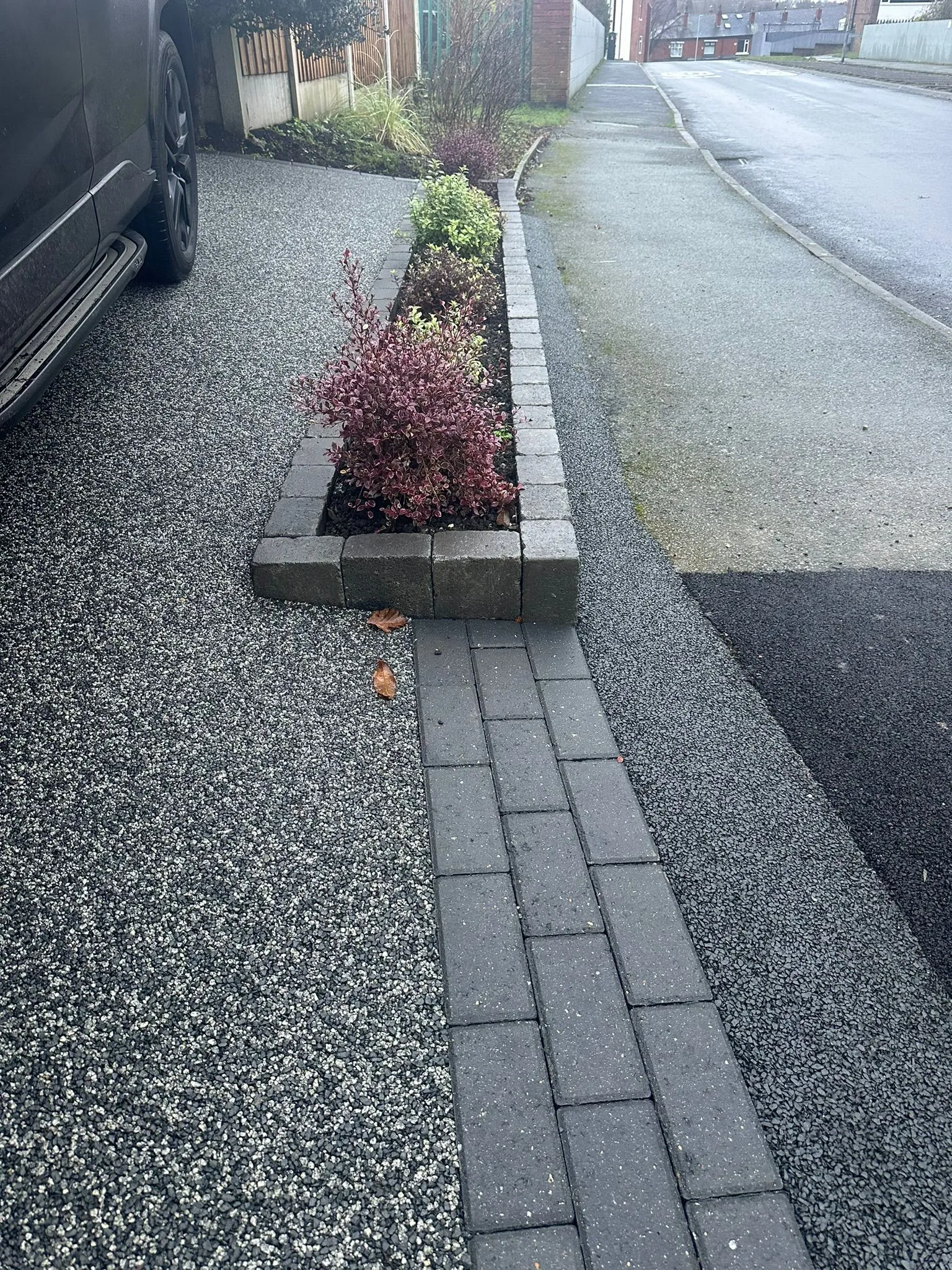Charcoal resin driveway with planter bed detail