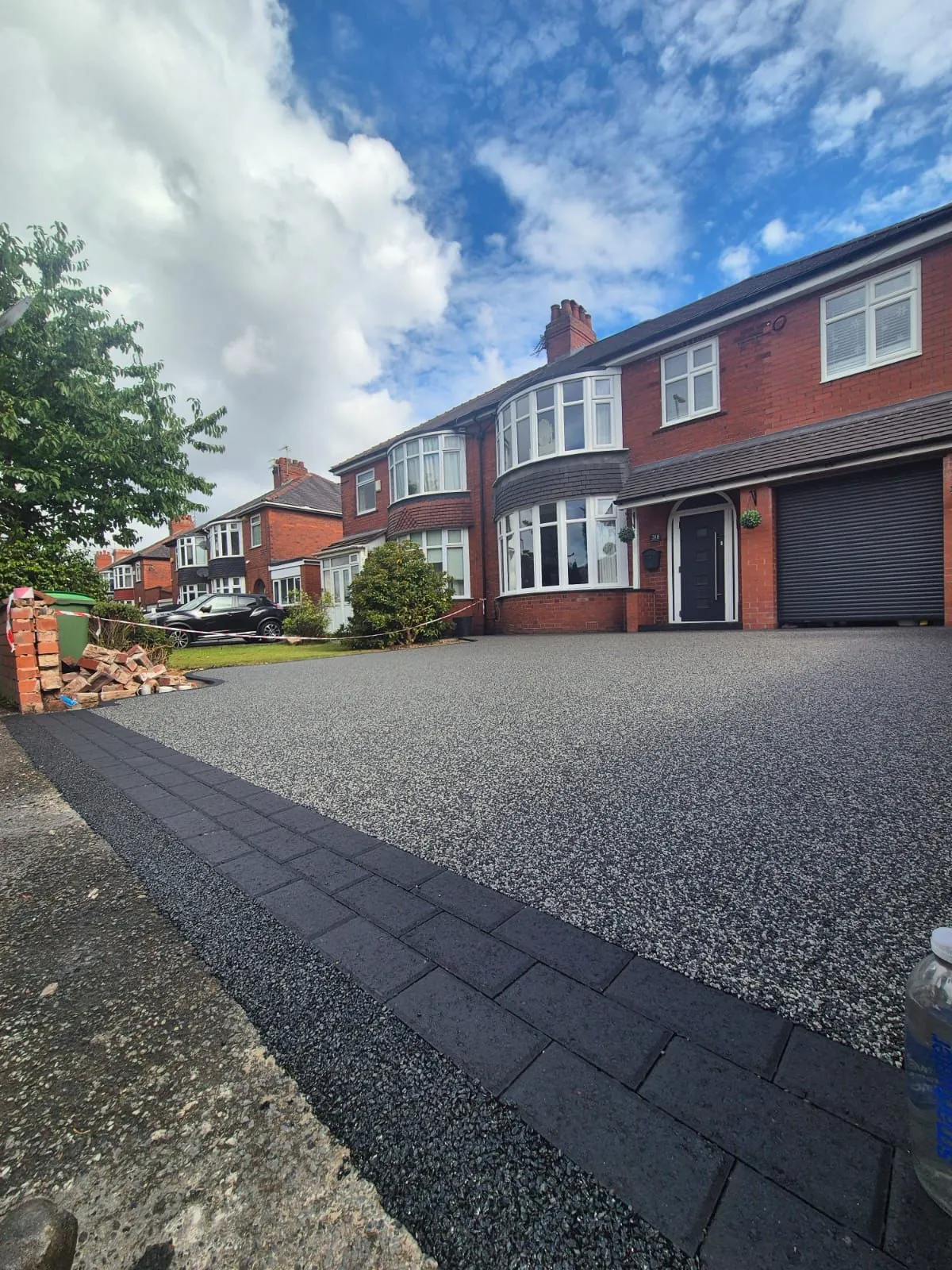Charcoal resin driveway at large red brick semi-detached