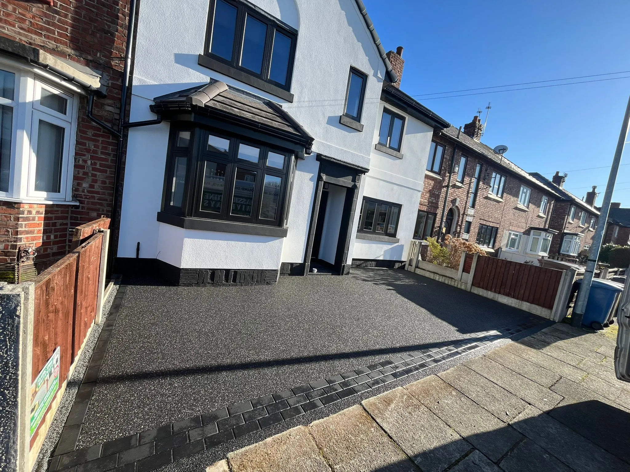 Charcoal resin driveway at white semi with bay window