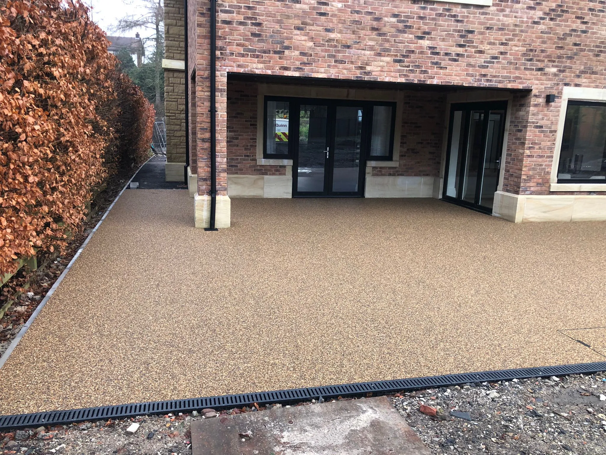 Copper resin drive with rear patio at semi-detached home