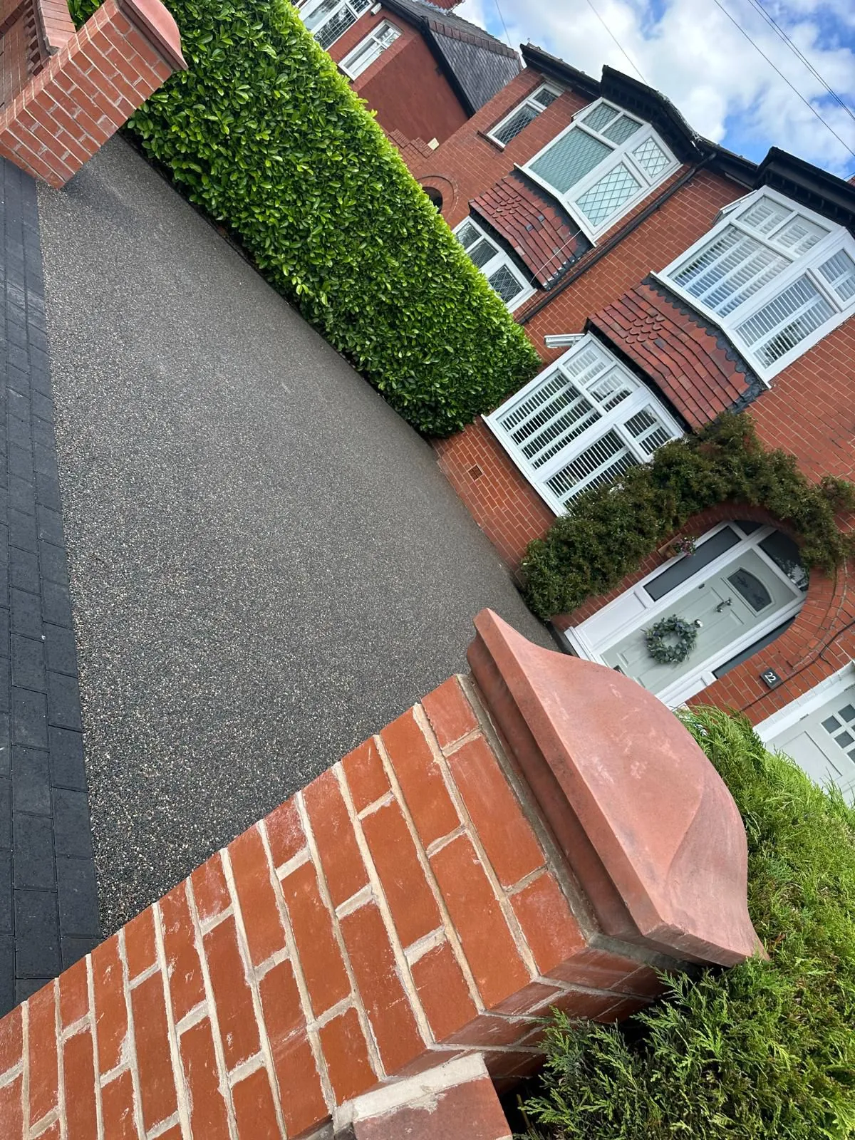 Grey resin drive with red brick pillar, Manchester