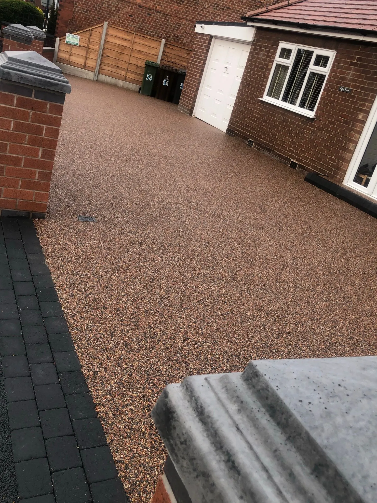 Honey resin drive at terraced house with brick wall