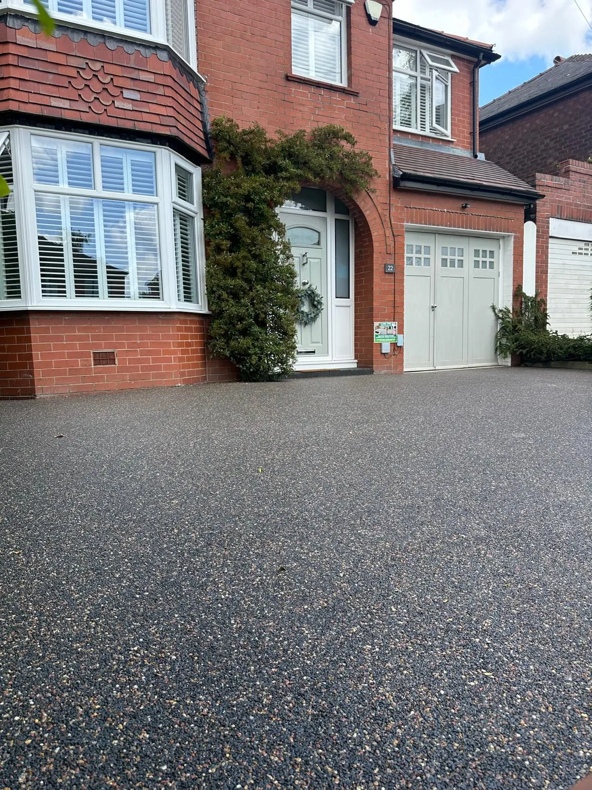Mid grey resin driveway at red brick home, Manchester
