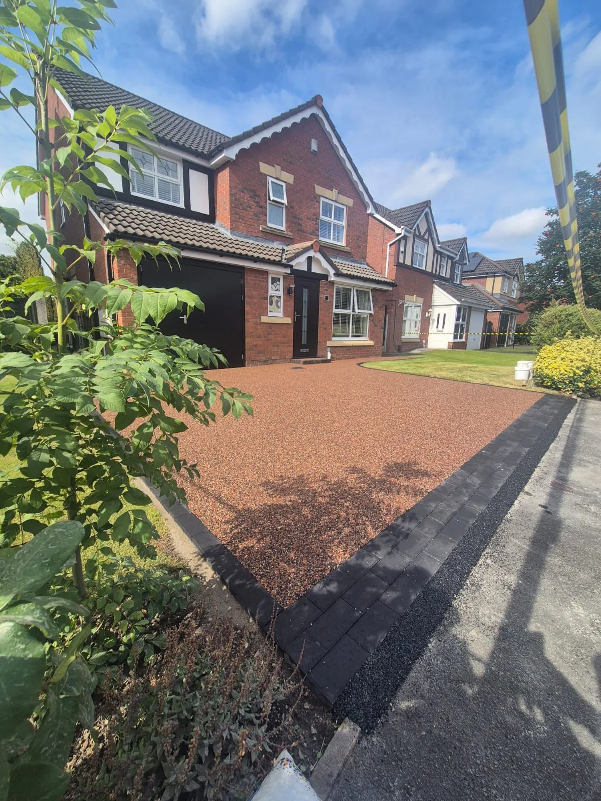 Red bronze resin driveway on a sunny day, Manchester