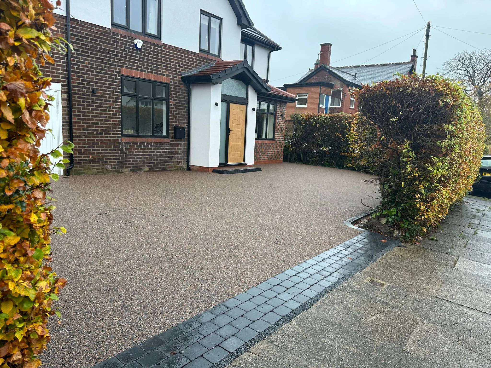 Russet resin drive at modern semi with porch, Manchester