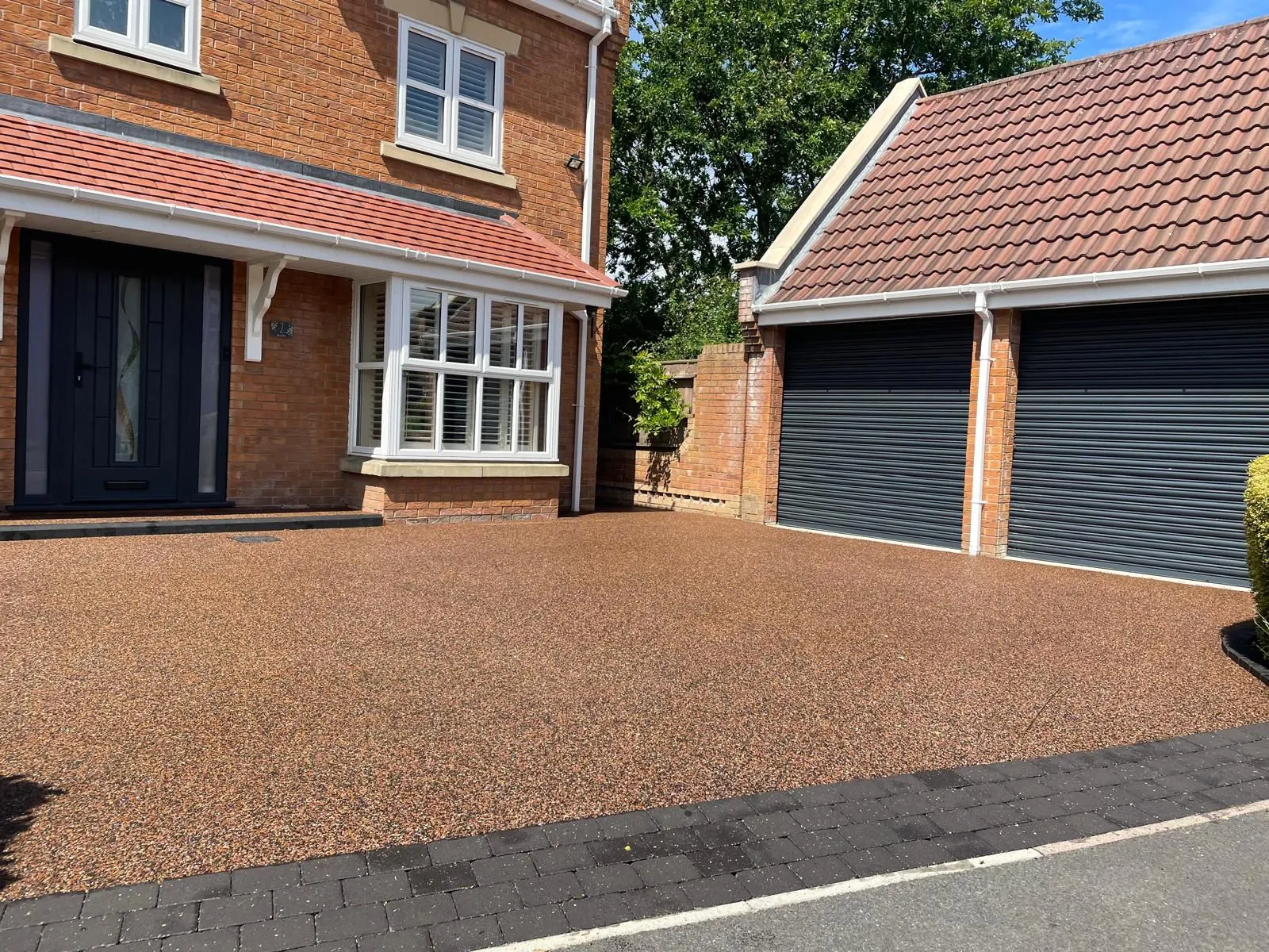 Rustic red resin drive at detached home, Manchester