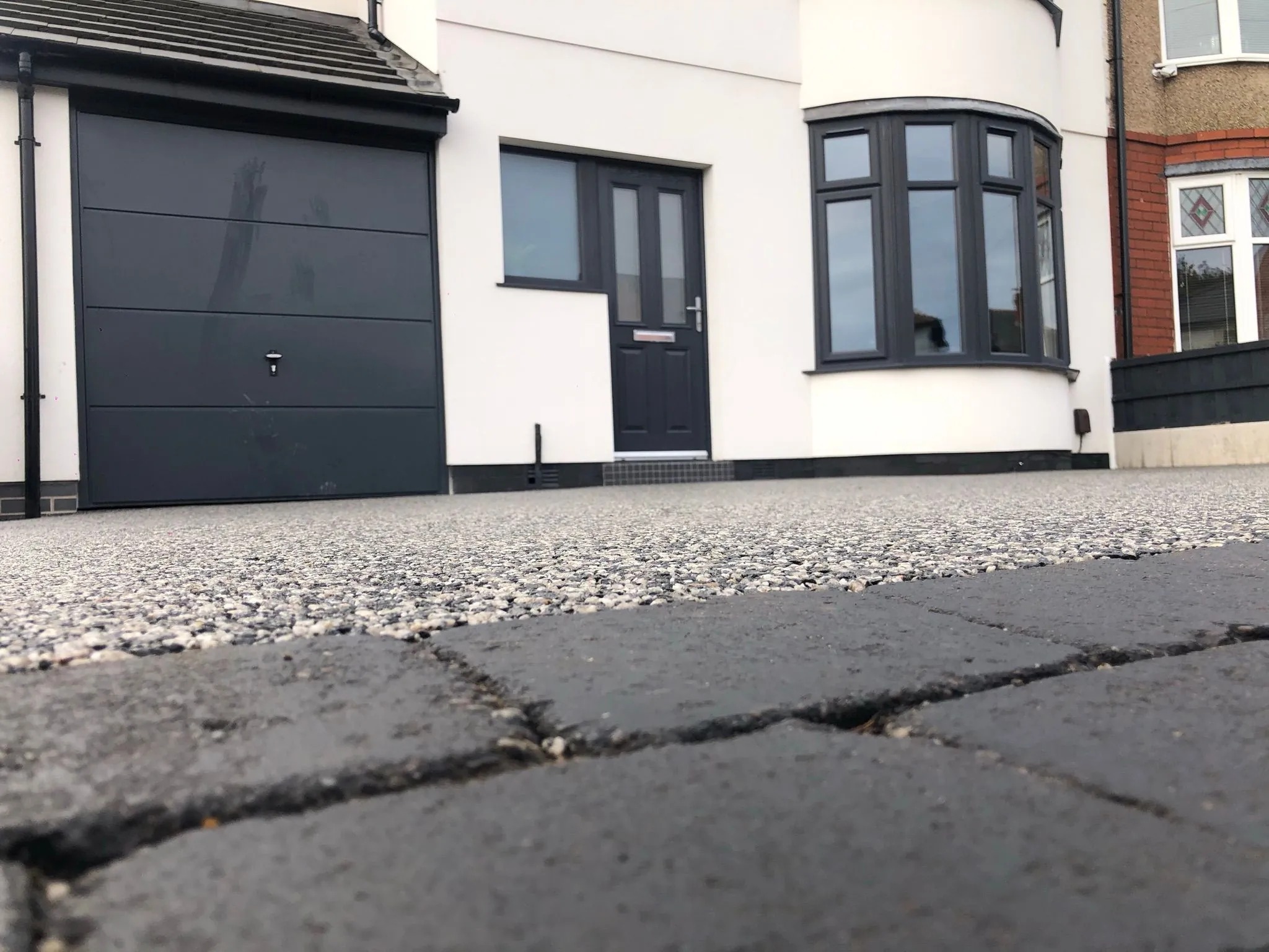Silver resin drive, low angle view of bay window home, Manchester