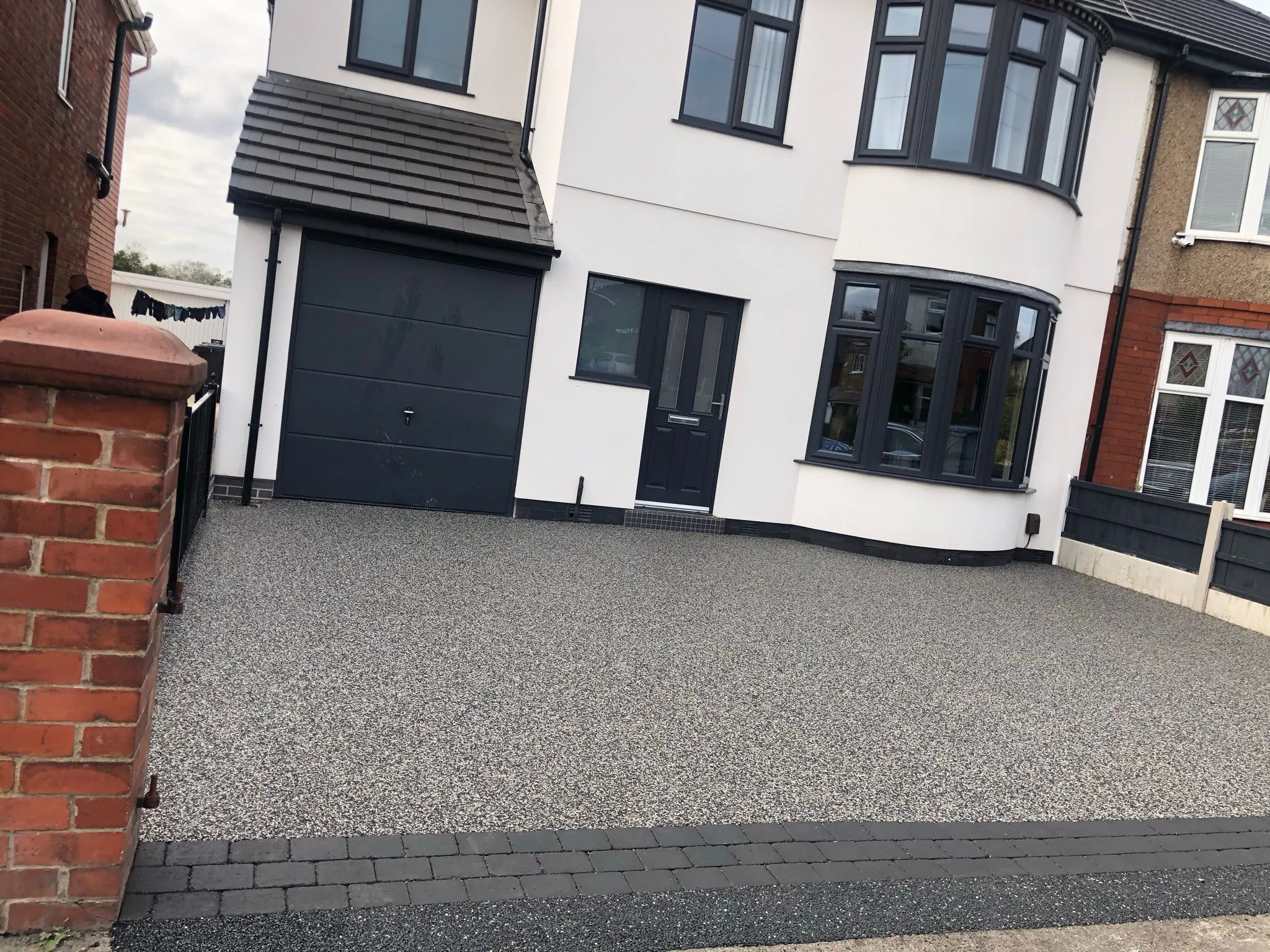 Silver resin driveway at white and grey semi-detached home, Manchester