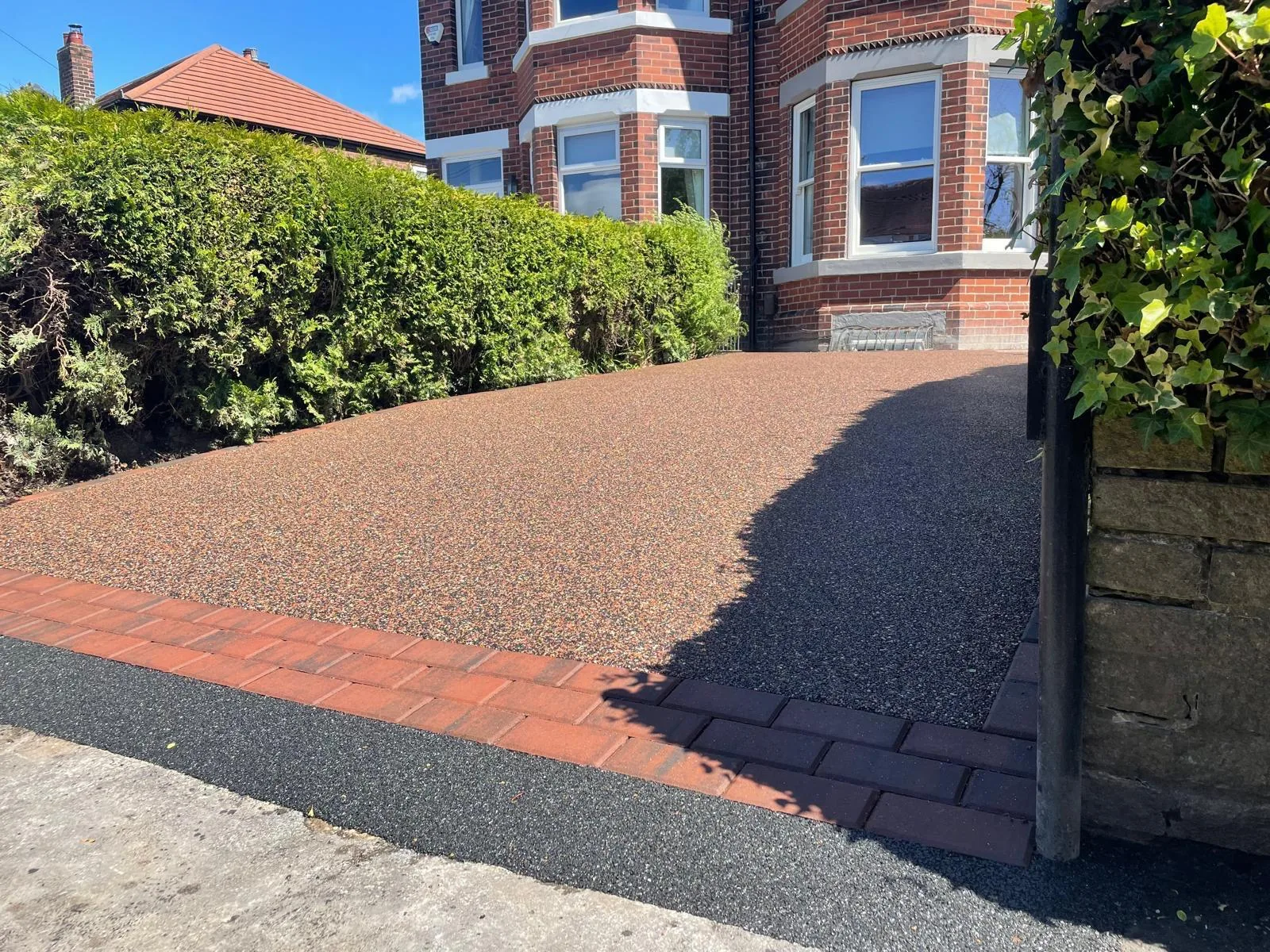 Brown resin bound driveway at a bay-window semi-detached house, Manchester