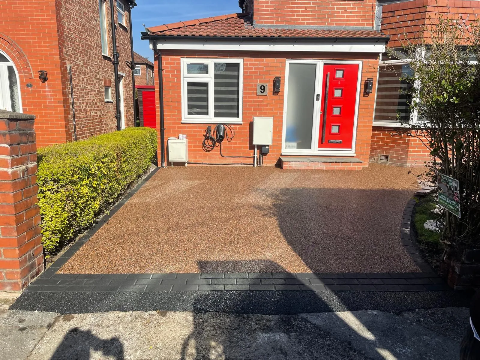 Brown resin bound driveway with red door and porch, Manchester