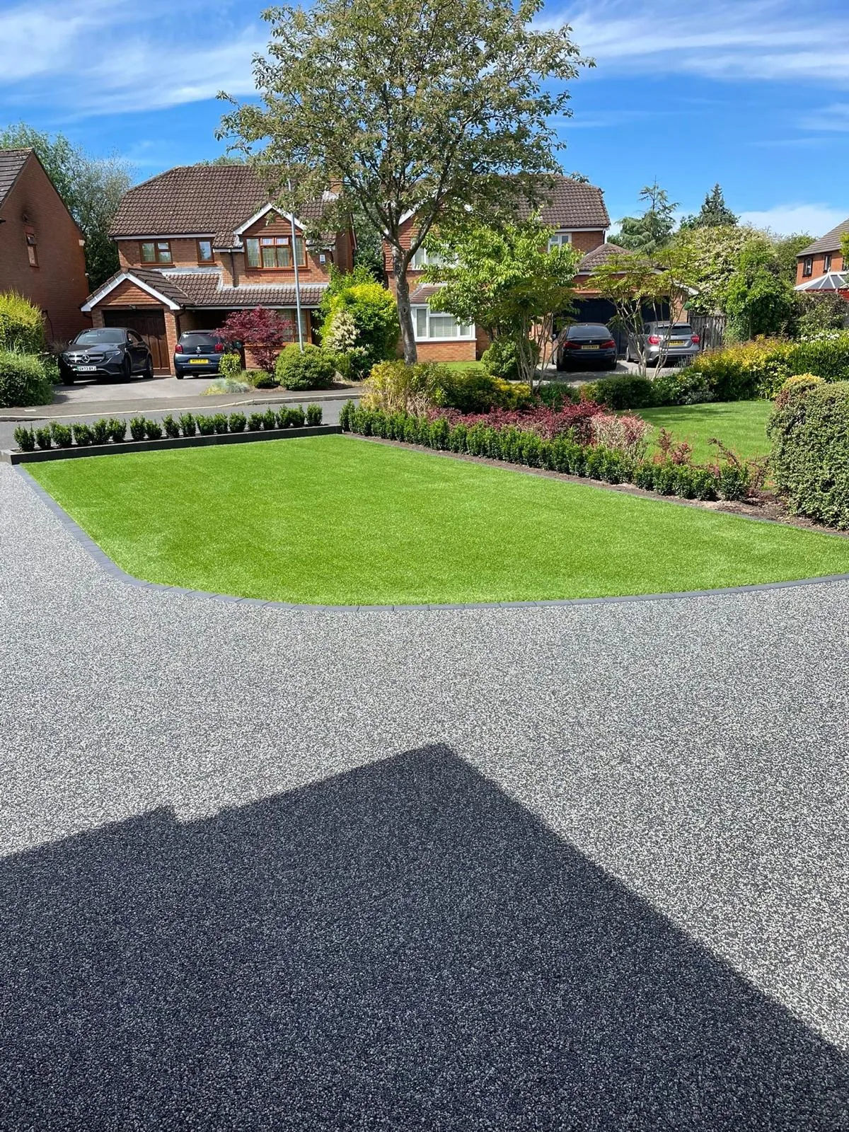 Charcoal resin bound driveway at a detached house with front lawn, Manchester