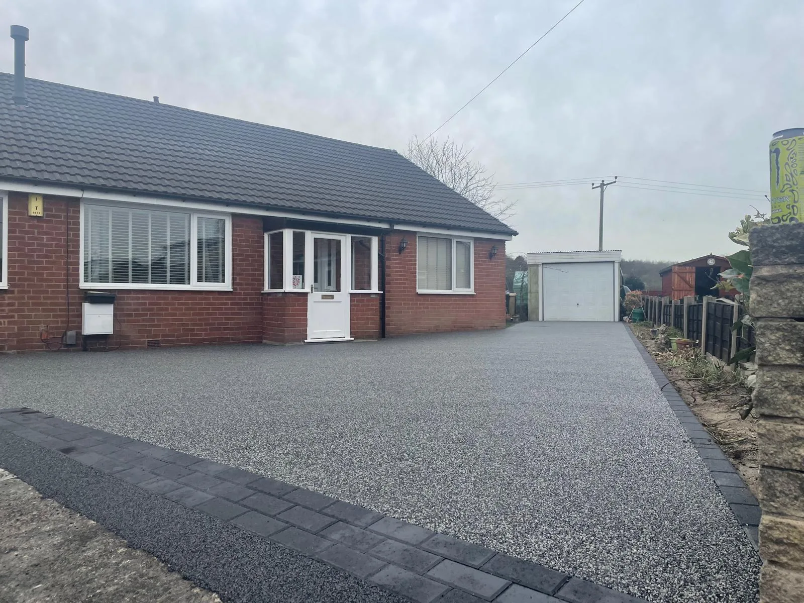 Charcoal resin bound driveway at a long bungalow frontage, Manchester