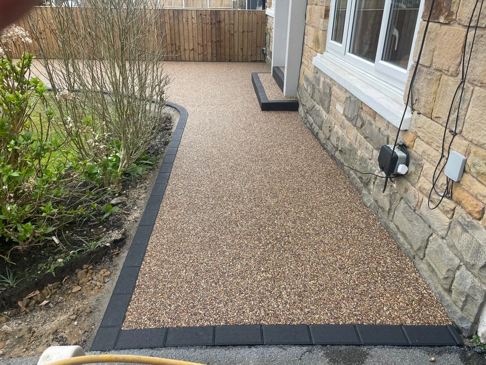 Copper resin bound driveway with charcoal block-paved border, Manchester