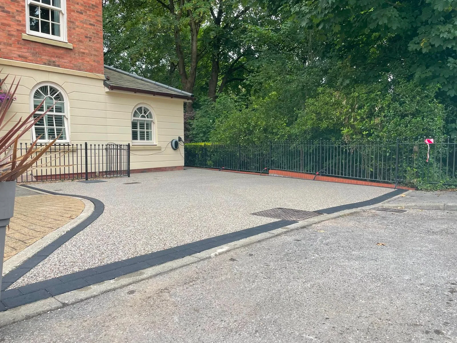 Charcoal block-paved border framing an Astley resin driveway