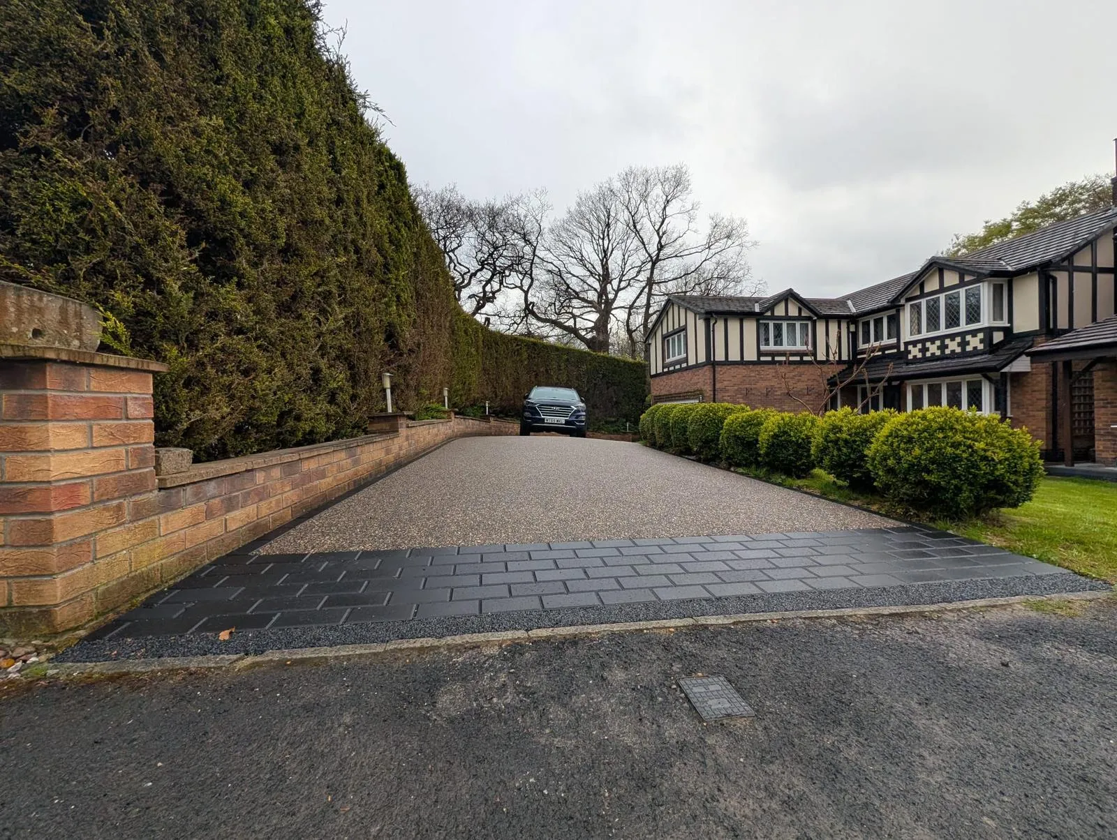 Charcoal block-paved apron at the road entrance of a Glossop resin driveway