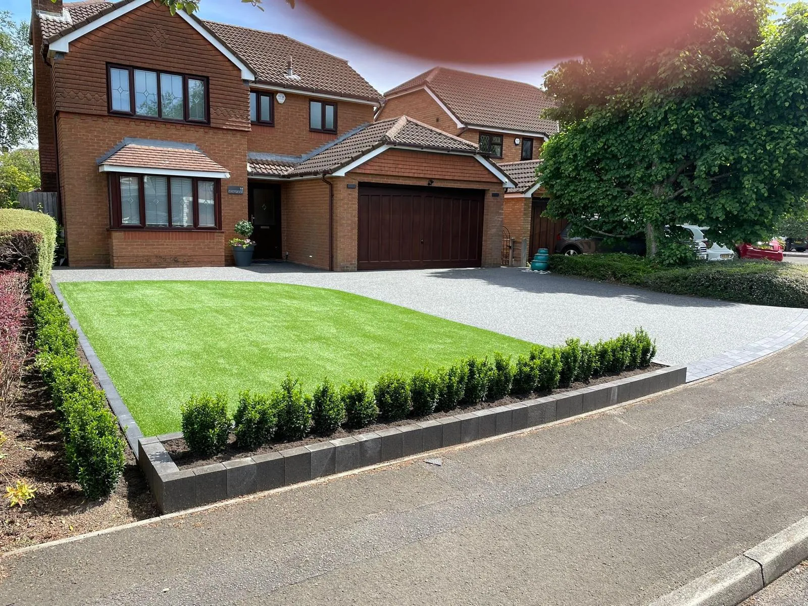 Silver resin driveway with box-hedge border and manicured lawn, Manchester