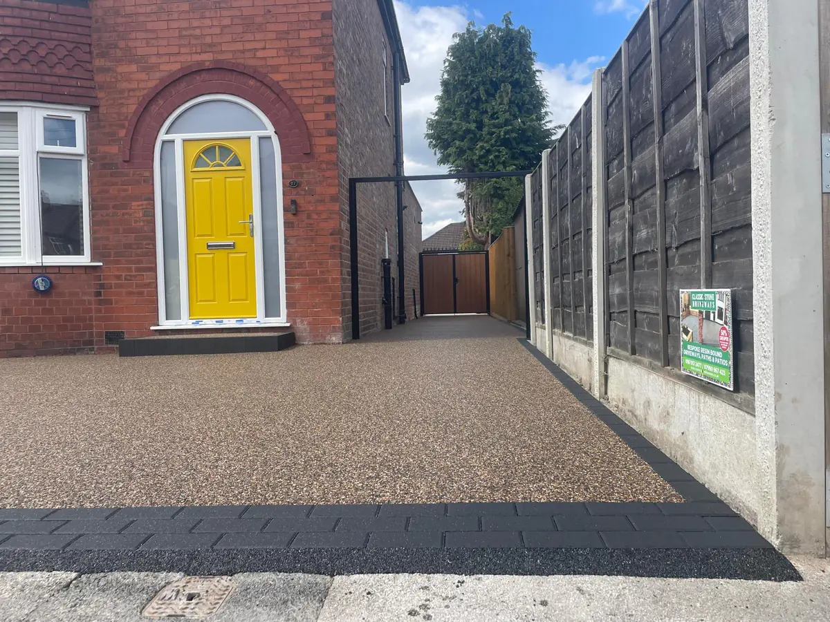 The resin driveway continuing past the house towards the side gate