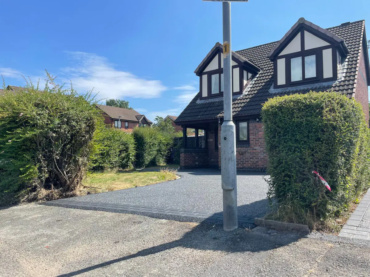 The black and silver resin driveway across the full frontage in Hyde